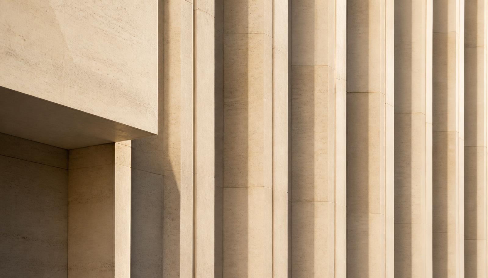 Detail of a limestone modernist facade in low sunlight